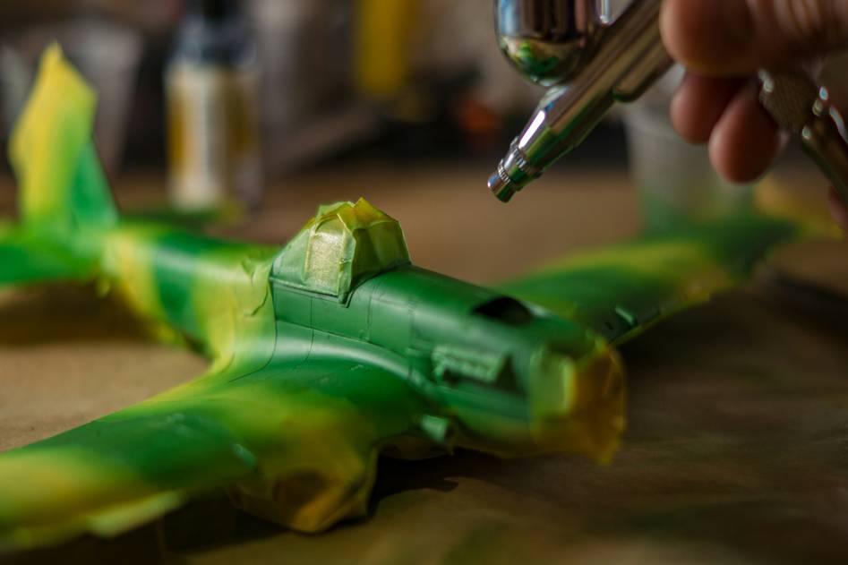 Airbrush kit spraying vibrant icing on a layered cake