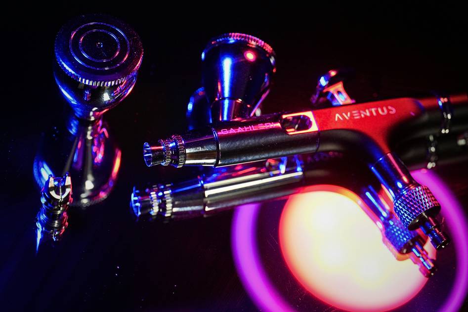Blogger reviewing airbrush tools on a kitchen countertop
